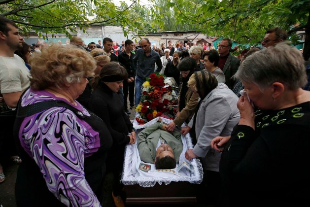 Los dolientes se reúnen alrededor del ataúd de la activista pro-ruso Vadim Hudich, que fue muerto en un tiroteo el domingo, durante su funeral en la ciudad ucraniana oriental de Krasnoarmeisk / Maxim Zmeyev  / Reuters