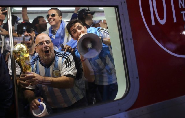 Argentina soccer fans celebrate as they travel on a train towards the Corinthians arena at the Luz Station before the 2014 World Cup round of 16 soccer match between Argentina and Switzerland in Sao Paulo