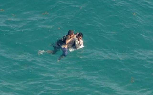 Dos hombres se aferran a los restos de una embarcación el lunes en la Bahía de Biscayne antes de ser rescatados.WSVN7 NEWS 