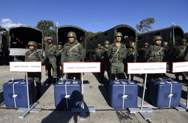 Members of the Venezuelan army stand next to electoral machines in Caracas on December 1, 2015. The Venezuelan opposition on Monday urged the armed forces to ensure that the results of the legislative elections of next Sunday are respected. AFP PHOTO/JUAN BARRETO / AFP / JUAN BARRETO