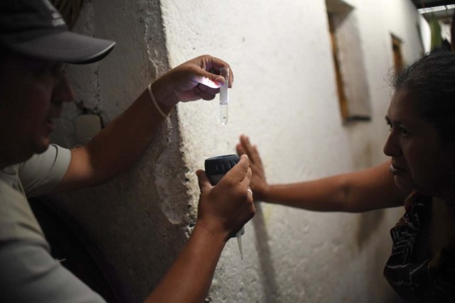 Health ministry workers show a larva of Aedes aegypti mosquito, vector of the dengue, Zika and Chikungunya viruses in the Bethania neighborhood in Guatemala City on February 2, 2016. World health officials mobilized with emergency response plans and funding pleas Tuesday as fears grow that the Zika virus, blamed for a surge in the number of brain-damaged babies, could spread globally and threaten the Summer Olympics. AFP PHOTO Johan ORDONEZ / AFP / JOHAN ORDONEZ