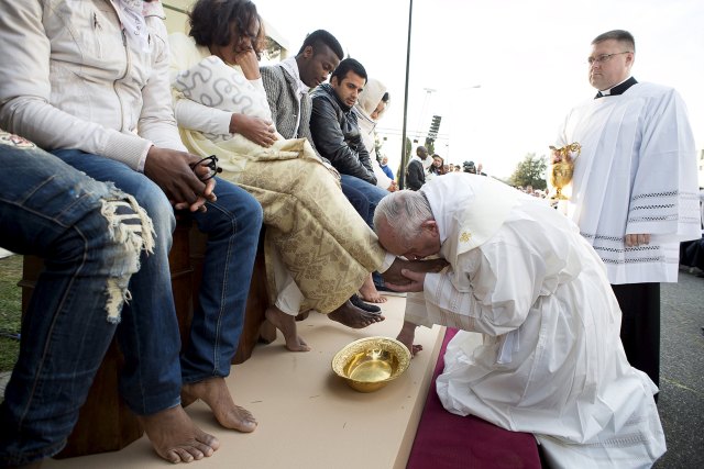 Pope Francis kisses the foot of a refugee during the foot-washing ritual at the Castelnuovo di Porto refugees center near Rome, Italy, March 24, 2016. Pope Francis on Thursday washed and kissed the feet of refugees, including three Muslim men, and condemned arms makers as partly responsible for Islamist militant attacks that killed at least 31 people in Brussels. REUTERS/Osservatore Romano/Handout via Reuters ATTENTION EDITORS - THIS PICTURE WAS PROVIDED BY A THIRD PARTY. REUTERS IS UNABLE TO INDEPENDENTLY VERIFY THE AUTHENTICITY, CONTENT, LOCATION OR DATE OF THIS IMAGE. EDITORIAL USE ONLY. NOT FOR SALE FOR MARKETING OR ADVERTISING CAMPAIGNS. NO RESALES. NO ARCHIVE. THIS PICTURE IS DISTRIBUTED EXACTLY AS RECEIVED BY REUTERS, AS A SERVICE TO CLIENTS.