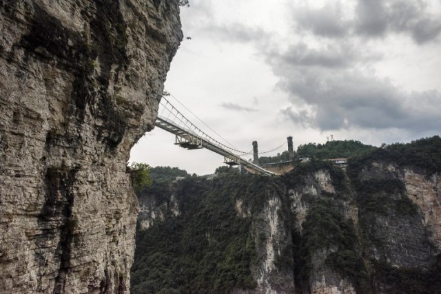 The world's highest and longest glass-bottomed bridge is seen above a valley in Zhangjiajie in China's Hunan Province on August 20, 2016. / AFP PHOTO / FRED DUFOUR