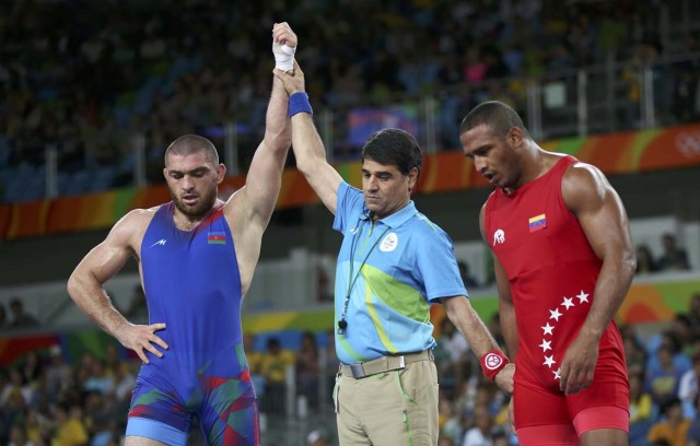 2016 Rio Olympics - Wrestling - Final - Men's Freestyle 86 kg Bronze - Carioca Arena 2 - Rio de Janeiro, Brazil - 20/08/2016. The referee raises the hand of Sharif Sharifov (AZE) of Azerbaijan after his victory against Pedro Ceballos Fuentes (VEN) of Venezuela. REUTERS/Toru Hanai FOR EDITORIAL USE ONLY. NOT FOR SALE FOR MARKETING OR ADVERTISING CAMPAIGNS.