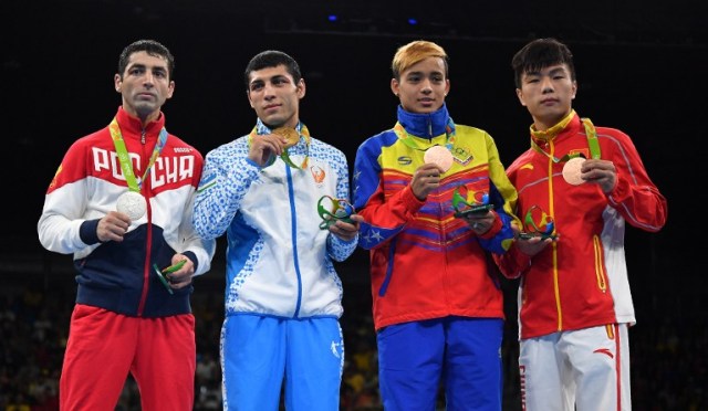 Gold medalist Uzbekistan's Shakhobidin Zoirov (2L), silver mealist Russia's Misha Aloian (L), and bronze medalists China's Hu Jianguan (R) and Venezuela's Yoel Segundo Finol react during the medal presentation ceremony following the Men's Fly (52kg) Final Bout at the Rio 2016 Olympic Games at the Riocentro - Pavilion 6 in Rio de Janeiro on August 21, 2016. / AFP PHOTO / Yuri CORTEZ