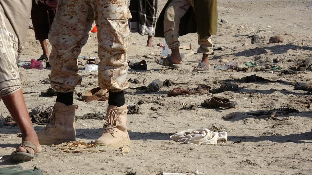 Soldiers stand near the shoes of comrades killed by a suicide bombing in the southern port city of Aden, Yemen December 18, 2016. REUTERS