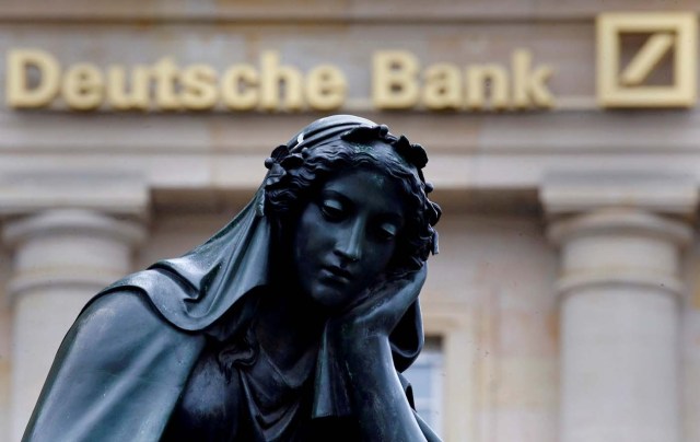 FILE PHOTO - A statue is seen next to the logo of Germany's Deutsche Bank in Frankfurt, Germany, January 26, 2016. REUTERS/Kai Pfaffenbach/File Photo