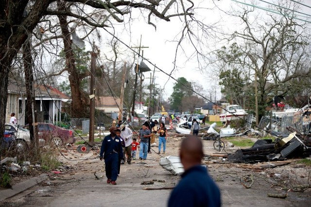 NEW ORLEANS, LA - FEBRUARY 07: Residents walk down a street along Chef Menture Ave after a tornado touched down in the eastern part of the city on February 7, 2017 in New Orleans, Louisiana. According to the weather service 25 people were injured in the aftermath of the tornado. Sean Gardner/Getty Images/AFP