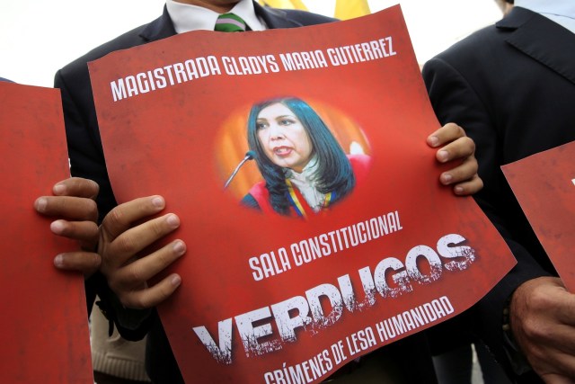 Juan Matheus, deputy of the opposition party Justice First (Primero Justicia) holds a placard with an image of Venezuela's Supreme Court President Gladys Gutierrez during a protest against Venezuelan President Nicolas Maduro's government outside the Supreme Court of Justice (TSJ) in Caracas, Venezuela February 9, 2017. REUTERS/Carlos Garcia Rawlins