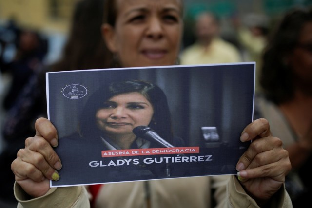 An opposition supporter holds a placard with an image of Venezuela's Supreme Court President Gladys Gutierrez that reads "Murderer of democracy", during a protest against Venezuelan President Nicolas Maduro's government outside the Supreme Court of Justice (TSJ) in Caracas, Venezuela February 9, 2017. REUTERS/Marco Bello