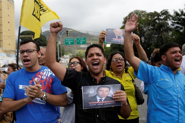 Opposition supporters holding images of judges shout slogans during a protest against Venezuelan President Nicolas Maduro's government outside the Supreme Court of Justice (TSJ) in Caracas, Venezuela February 9, 2017. REUTERS/Marco Bello