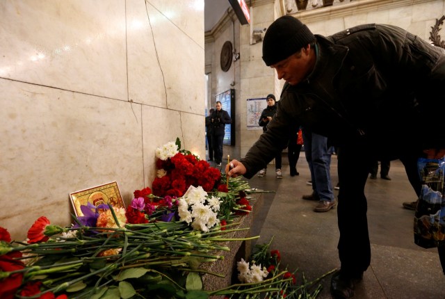 A man leaves a candle in memory of victims of a blast in St.Petersburg metro, at Tekhnologicheskiy institut metro station in St. Petersburg, Russia, April 4, 2017. REUTERS/Grigory Dukor