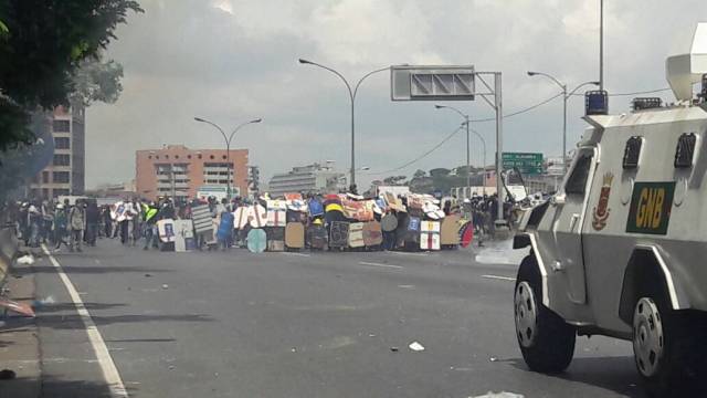 Manifestantes con escudos frente a tanqueta que reprime movilización / Foto: Eduardo Ríos
