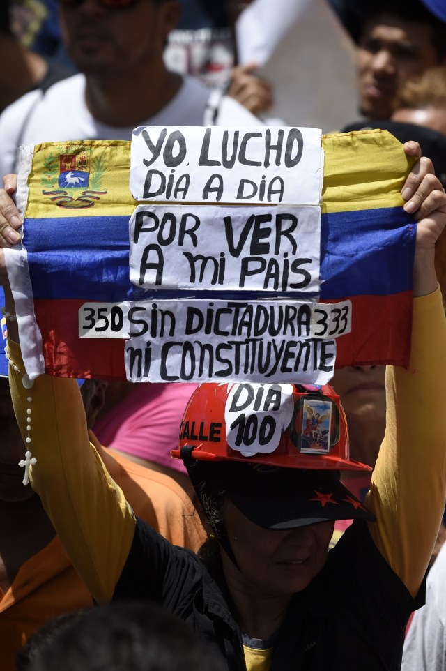 An opposition activist demonstrates against Venezuelan President Nicolas Maduro in Caracas, on July 9, 2017. Venezuela hit its 100th day of anti-government protests on Sunday, one day after its most prominent political prisoner, Leopoldo Lopez, vowed to continue his fight for freedom after being released from jail and placed under house arrest. At least 91 people have died since non-stop street protests began on April 1. / AFP PHOTO / Juan BARRETO