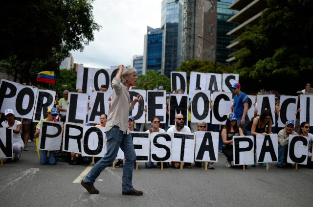 An opposition activist shouts slogans during a demonstration against Venezuelan President Nicolas Maduro in Caracas, on July 9, 2017. Venezuela hit its 100th day of anti-government protests on Sunday, one day after its most prominent political prisoner, Leopoldo Lopez, vowed to continue his fight for freedom after being released from jail and placed under house arrest. At least 91 people have died since non-stop street protests began on April 1. / AFP PHOTO / Federico PARRA