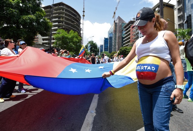 A pregnant opposition activist with the word "Freedom" written on her belly takes part in a demonstration against Venezuelan President Nicolas Maduro in Caracas, on July 9, 2017. Venezuela hit its 100th day of anti-government protests on Sunday, one day after its most prominent political prisoner, Leopoldo Lopez, vowed to continue his fight for freedom after being released from jail and placed under house arrest. At least 91 people have died since non-stop street protests began on April 1. / AFP PHOTO / Juan BARRETO