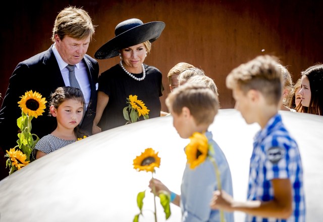 Dutch King Willem-Alexander (L) and Queen Maxima (C) attend the unveiling of the National Monument for the MH17 victims in Vijfhuizen on July 17, 2017. Three years after Flight MH17 was shot down by a missile over war-torn Ukraine, more than 2,000 relatives gather to unveil a "living memorial" to their loved ones. A total of 298 trees have been planted in the shape of a green ribbon, one for each of the victims who died on board the Malaysia Airlines flight en route from Amsterdam to Kuala Lumpur. The flowers also represent "the sunflower fields in eastern Ukraine where some parts of the plane wreckage were found". / AFP PHOTO / ANP / Remko de Waal / Netherlands OUT