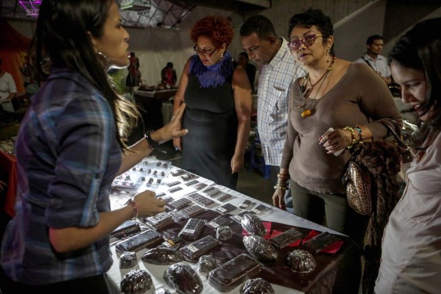 ACOMPAÑA CRÓNICA: VENEZUELA GASTRONOMÍA. CAR07. CARACAS (VENEZUELA), 29/09/2017.- Fotografía fechada el 28 de septiembre de 2017 que muestra a varias personas mientras evalúan una exhibición de productos derivados del cacao en Caracas (Venezuela). La industria del chocolate en Venezuela organiza su V Expoferia Internacional para "darle impulso" exportador a sus productos, en medio de la rampante crisis económica que atraviesa el país petrolero, y con la mira puesta en otro récord Guinness que promocione el llamado "mejor cacao del mundo". EFE/Cristian Hernández