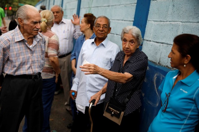 Los ciudadanos de Venezuela conversan mientras esperan emitir sus votos en una mesa de votación durante una elección nacional para nuevos gobernadores, en Caracas, Venezuela, el 15 de octubre de 2017. REUTERS / Carlos Garcia Rawlins