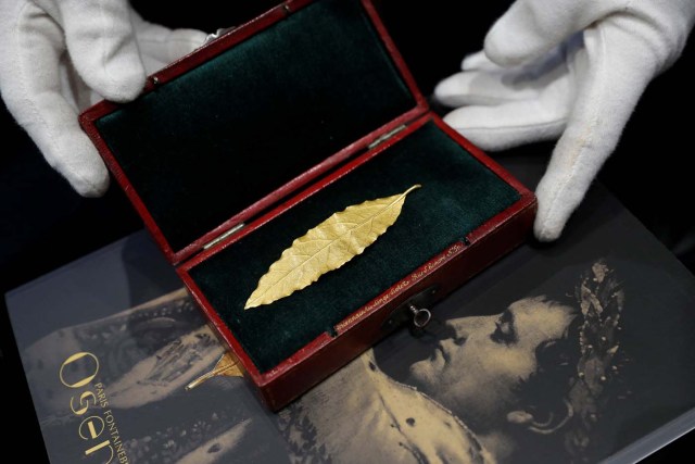 An auctioneer displays a gold laurel leaf from French Emperor Napoleon's imperial crown at the office of the Osenat auction house in Paris, France, November 15, 2017. The leaf will go under the hammer on Sunday and is expected to fetch between 100,000 and 150,000 euros. REUTERS/Philippe Wojazer
