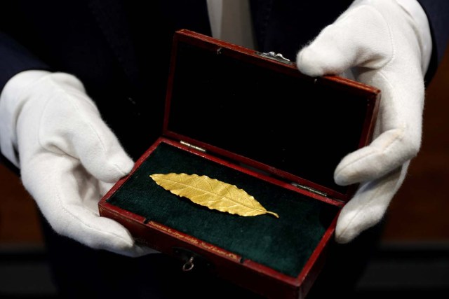 An auctioneer displays a gold laurel leaf from French Emperor Napoleon's imperial crown at the office of the Osenat auction house in Paris, France, November 15, 2017. The leaf will go under the hammer on Sunday and is expected to fetch between 100,000 and 150,000 euros. REUTERS/Philippe Wojazer TPX IMAGES OF THE DAY