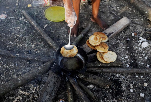 An indigenous Warao woman from the Orinoco Delta in eastern Venezuela, makes bread at a shelter in Pacaraima, Roraima state, Brazil November 15, 2017. Picture taken November 15, 2017. REUTERS/Nacho Doce