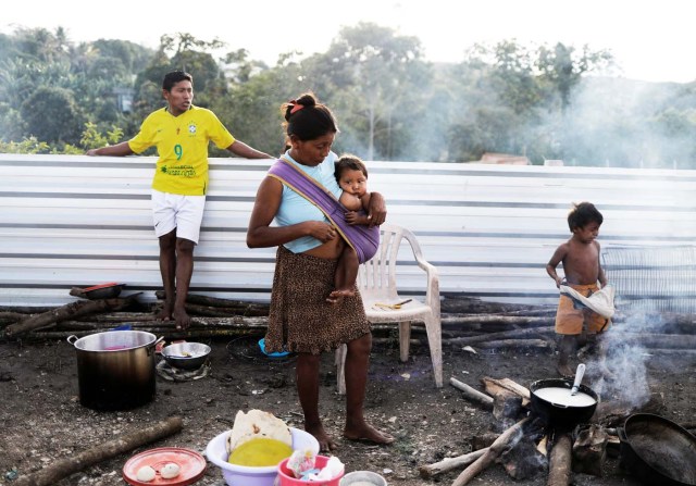 Indigenous Warao people from the Orinoco Delta in eastern Venezuela, stand next to food at a shelter in Pacaraima, Roraima state, Brazil November 15, 2017. Picture taken November 15, 2017. REUTERS/Nacho Doce TEMPLATE OUT
