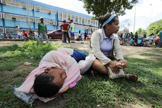 People lay on the grass outside a health center as they wait to get treatment for malaria, in San Felix, Venezuela November 3, 2017. Picture taken November 3, 2017. REUTERS/William Urdaneta