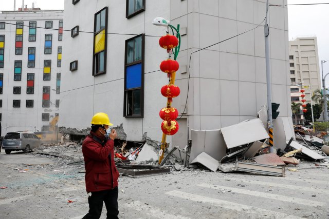 Un hombre camina entre escombros afuera de un hotel dañado después de que un terremoto golpeara a Hualien, Taiwán el 7 de febrero de 2018. REUTERS / Tyrone Siu