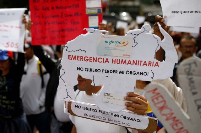 Reinaldo Olivares, a kidney transplanted patient, holds a placard with the shape of the map of Venezuela that reads, "Humanitarian emergency. I do not want to lose my organ", during a protest against medicinal shortages in Caracas, Venezuela February 8, 2018. Picture taken February 8, 2018. REUTERS/Carlos Garcia Rawlins