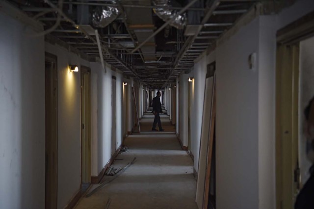 This photograph taken on March 7, 2018 shows an Afghan man walking along a corridor of the Intercontinental Hotel in Kabul. Richard Clayderman's sweet-sounding "Romeo and Juliet" piano music accompanied Taliban gunmen as they rode in gold mirrored elevators to the upper floors of a Kabul luxury hotel in January in search of foreign guests to kill. At least 25 people, including 15 foreigners, were killed. Nearly seven weeks on, AFP was allowed to inspect the still badly damaged hilltop hotel overlooking the Afghan capital as it partially reopened its doors to the reluctant public. / AFP PHOTO / SHAH MARAI / TO GO WITH 'AFGHANISTAN-UNREST-HOTEL' SCENE by ALLISON JACKSON and EMAL HAIDARY