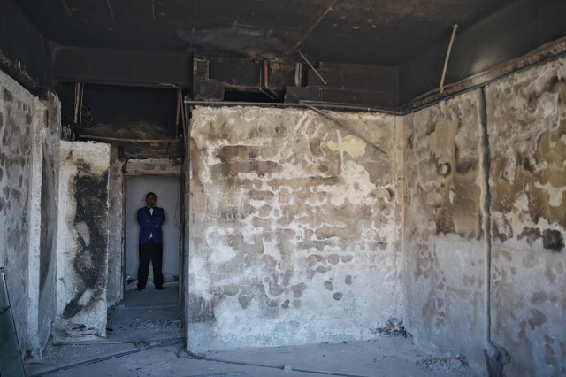 This photograph taken on March 7, 2018 shows an Afghan man standing inside a burnt room at the Intercontinental Hotel in Kabul. Richard Clayderman's sweet-sounding "Romeo and Juliet" piano music accompanied Taliban gunmen as they rode in gold mirrored elevators to the upper floors of a Kabul luxury hotel in January in search of foreign guests to kill. At least 25 people, including 15 foreigners, were killed. Nearly seven weeks on, AFP was allowed to inspect the still badly damaged hilltop hotel overlooking the Afghan capital as it partially reopened its doors to the reluctant public. / AFP PHOTO / SHAH MARAI / TO GO WITH 'AFGHANISTAN-UNREST-HOTEL' SCENE by ALLISON JACKSON and EMAL HAIDARY