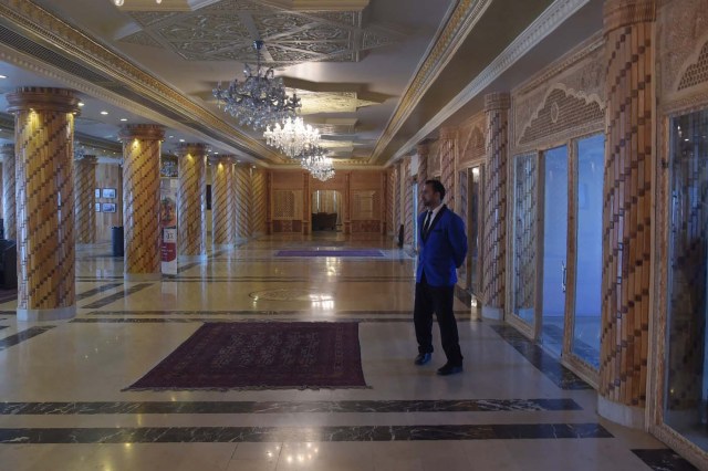 This photograph taken on March 7, 2018 shows a bellboy standing at a hall of the Intercontinental Hotel in Kabul. Richard Clayderman's sweet-sounding "Romeo and Juliet" piano music accompanied Taliban gunmen as they rode in gold mirrored elevators to the upper floors of a Kabul luxury hotel in January in search of foreign guests to kill. At least 25 people, including 15 foreigners, were killed. Nearly seven weeks on, AFP was allowed to inspect the still badly damaged hilltop hotel overlooking the Afghan capital as it partially reopened its doors to the reluctant public. / AFP PHOTO / SHAH MARAI / TO GO WITH 'AFGHANISTAN-UNREST-HOTEL' SCENE by ALLISON JACKSON and EMAL HAIDARY