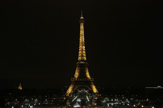 The lights of the Eiffel Tower are seen before they are dimmed at midnight, March 23, 2018 in Paris to honor victims killed at a supermarket in southwest France by a man claiming allegiance to the Islamic State. Paris Mayor Anne Hidalgo announced that the Eiffel Tower would switch off its light at midnight to honour the victims. / AFP PHOTO / Zakaria ABDELKAFI