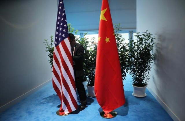 En la imagen de archivo un funcionario chino prepara las banderas de China y Estados unidos previo a la reunión bilatereal  en la cumbre de líderes del G20 en Hamburgo, Alemania.  8 de julio de 2017. REUTERS/Carlos Barria.