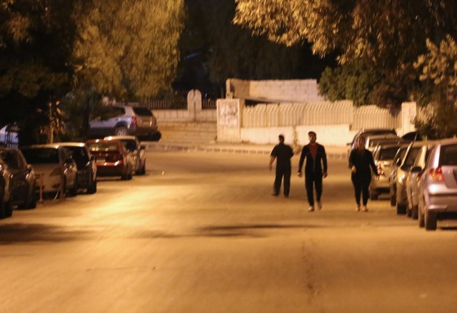 A photo taken in the early hours of April 14, 2018 shows pedestrians walking in an empty street before the daybreak Muslim prayer in Damascus' Mazze neighbourhood after the US, France, and Britain launched a joint operation against the Syrian government. Western strikes early Saturday hit Syrian military bases and research centres in and around the capital and the country's centre, a monitor said, as the US, France, and Britain announced a joint operation. / AFP PHOTO / STRINGER