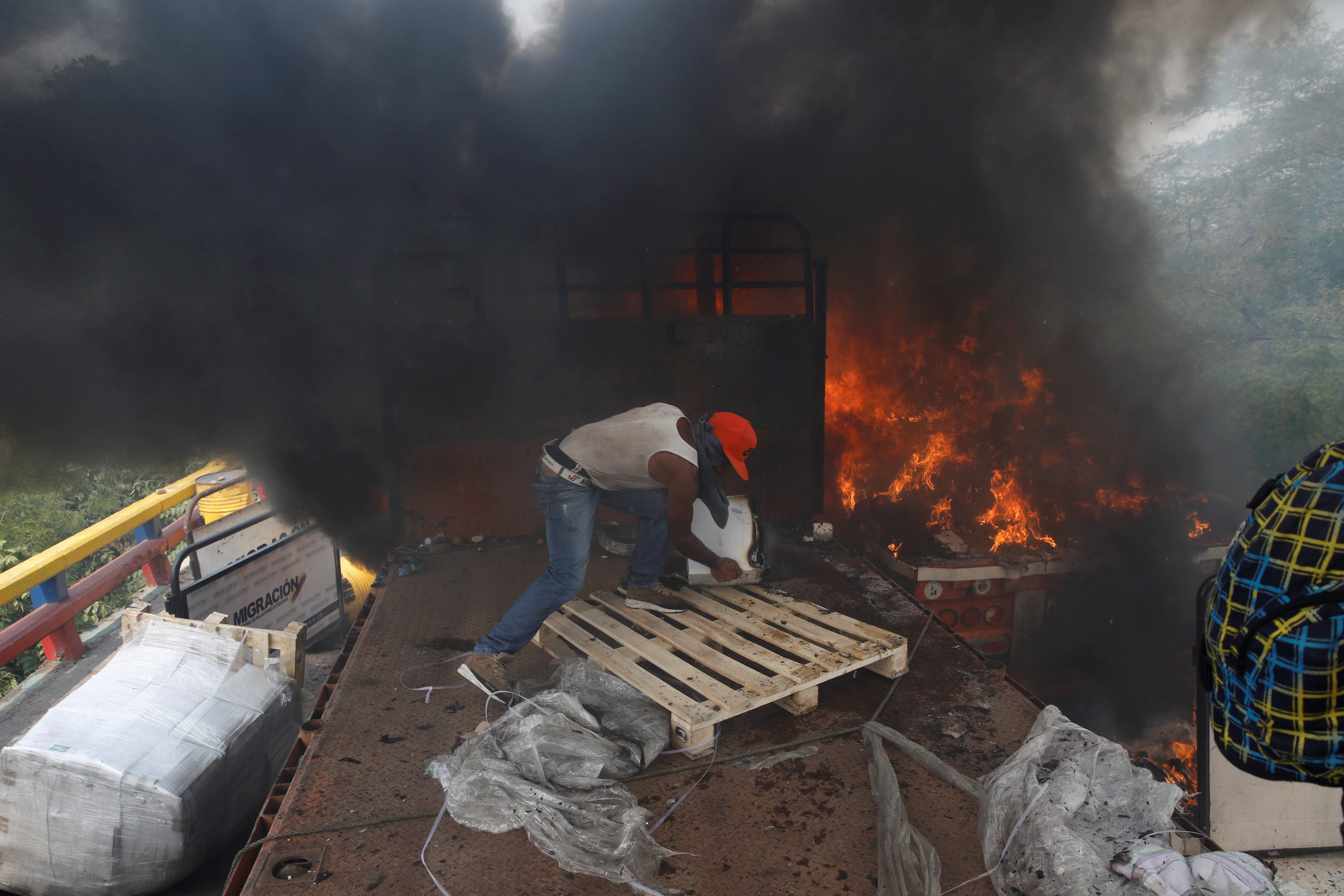 EN FOTOS: Con las manos desnudas y valentía, venezolanos intentan salvar la ayuda de las llamas